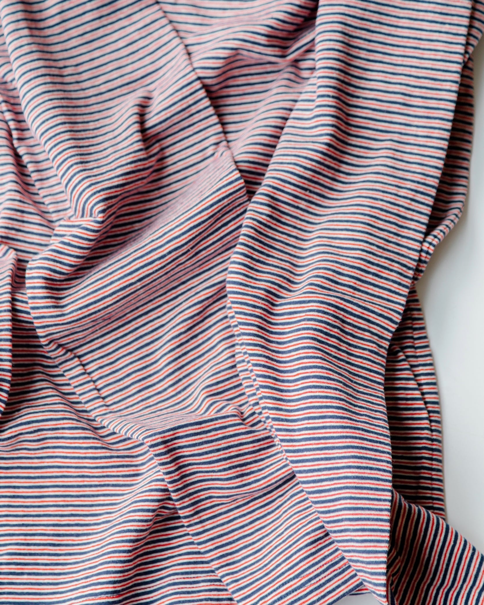 Close-up of a striped fabric with red and blue lines on a white background